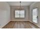 Dining room features wood flooring, a modern light fixture, and a window at 2090 Harvester Ln, Buford, GA 30518