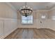 Bright entryway featuring board and batten trim, a stylish chandelier, and wood-look floors at 2090 Harvester Ln, Buford, GA 30518