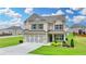 Beautiful two-story brick home with a manicured lawn, two-car garage, and stylish window shutters at 2090 Harvester Ln, Buford, GA 30518