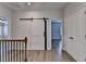 Hallway with hardwood floors, white walls, a sliding barn door and a door to a closet at 2090 Harvester Ln, Buford, GA 30518