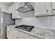 Close-up of kitchen featuring a gas range, granite counters, and stainless vent hood at 2090 Harvester Ln, Buford, GA 30518