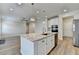 Open kitchen layout featuring stainless appliances, a granite-topped island, and wood flooring at 2090 Harvester Ln, Buford, GA 30518