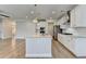 Open-concept kitchen featuring an eat-in island, stainless appliances, pendant lights, and wood flooring at 2090 Harvester Ln, Buford, GA 30518