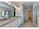 Bathroom featuring double sinks, granite counters, and tile shower with glass doors at 2090 Harvester Ln, Buford, GA 30518