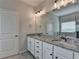 Main bathroom featuring dual sinks with granite countertops and large mirror at 2090 Harvester Ln, Buford, GA 30518