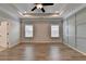 Main bedroom featuring tray ceilings, recessed lighting, a ceiling fan, wood floors and wainscoting at 2090 Harvester Ln, Buford, GA 30518