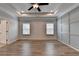 Main bedroom featuring tray ceilings, recessed lighting, a ceiling fan and wood floors at 2090 Harvester Ln, Buford, GA 30518