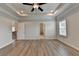 Spacious main bedroom featuring a trey ceiling, ceiling fan and wood-look floors at 2090 Harvester Ln, Buford, GA 30518