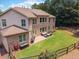 Brick home with a spacious backyard featuring a patio, lush green grass, and wood fence at 3315 High Noontide Nw Way, Acworth, GA 30101