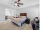 Comfortable bedroom with a dark wood bed frame and a seating area, illuminated by a ceiling fan at 3315 High Noontide Nw Way, Acworth, GA 30101