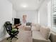 Bright bonus room with plush carpeting, a large sectional sofa, and a gaming chair near the tv at 3315 High Noontide Nw Way, Acworth, GA 30101