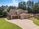 Brick home with attached garage, large parking area, and green lawn at 3315 High Noontide Nw Way, Acworth, GA 30101