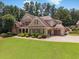 A side view of a brick house shows a well-manicured lawn, attractive landscaping, and a two-car garage at 3315 High Noontide Nw Way, Acworth, GA 30101