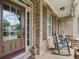 Inviting front porch with rocking chairs, brick siding, and a glass paneled front door at 3315 High Noontide Nw Way, Acworth, GA 30101