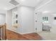 Hallway with hardwood floors, leading to a carpeted living area with a comfortable armchair at 3315 High Noontide Nw Way, Acworth, GA 30101