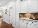 A bright hallway featuring a granite-topped bar area with white cabinets and hardwood flooring at 3315 High Noontide Nw Way, Acworth, GA 30101