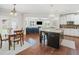 Modern kitchen with hardwood floors, a kitchen island with seating, and an adjacent dining area with a wood table at 3315 High Noontide Nw Way, Acworth, GA 30101