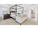 Main bedroom suite with a four-poster bed and a cozy sitting area with a view of the bathroom at 3315 High Noontide Nw Way, Acworth, GA 30101