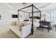 Main bedroom suite with a four-poster bed and a cozy sitting area with plenty of natural light at 3315 High Noontide Nw Way, Acworth, GA 30101
