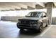 A grey Range Rover parked in a brightly lit garage under large support beams at 400 17Th St # 2325, Atlanta, GA 30363