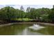 Peaceful pond view with a fountain, trees, and seating in a tranquil community setting at 400 17Th St # 2325, Atlanta, GA 30363