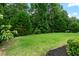 Lush green backyard featuring a large grassy area and mature trees at 1626 Waterchase Dr, Dacula, GA 30019