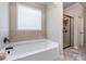 Bright bathroom featuring a soaking tub and a separate glass-enclosed shower at 1626 Waterchase Dr, Dacula, GA 30019