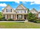 Charming two-story home boasts a manicured lawn, stone accents, symmetrical design, and a welcoming front porch at 1626 Waterchase Dr, Dacula, GA 30019