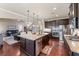 Open kitchen and living area featuring dark cabinets, granite counters, and stainless steel appliances at 1626 Waterchase Dr, Dacula, GA 30019