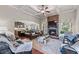 Open-concept living room featuring a stone fireplace, hardwood floors, and comfortable seating at 1626 Waterchase Dr, Dacula, GA 30019