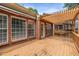 Wooden deck with a pergola offers a relaxing outdoor space adjacent to the brick house with large windows at 2132 Wrights Mill Ne Cir, Atlanta, GA 30324
