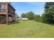 Large backyard with lush green grass, bordered by mature trees and landscaping, creating a private and peaceful setting at 47 Powder Springs St, Hiram, GA 30141