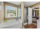 Bathroom with a soaking tub, shower, and a bright window at 47 Powder Springs St, Hiram, GA 30141