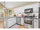 Bright kitchen with stainless steel appliances, grey countertops, white cabinets and hardwood floors at 47 Powder Springs St, Hiram, GA 30141