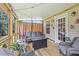 Cozy screened porch with outdoor furniture, a fire pit, and view of the trees and backyard at 47 Powder Springs St, Hiram, GA 30141