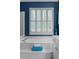 Bright bathroom featuring a large tub beneath shuttered windows with blue walls at 520 Weatherend Ct, Johns Creek, GA 30022
