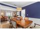 Well-lit dining room with blue accent wall and traditional wood furniture open to the living room at 520 Weatherend Ct, Johns Creek, GA 30022