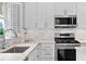 Modern kitchen with white countertops, stainless steel appliances, and ample cabinet space at 520 Weatherend Ct, Johns Creek, GA 30022