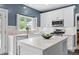 Modern kitchen boasts white cabinets, stainless steel appliances, marble countertops, and island with fruit display at 520 Weatherend Ct, Johns Creek, GA 30022