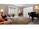 Elegant living room featuring a grand piano, decorative rug, and bay window with bright, natural light at 520 Weatherend Ct, Johns Creek, GA 30022