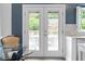 Kitchen door leads to outdoor dining on the backyard patio overlooking greenery and pool at 520 Weatherend Ct, Johns Creek, GA 30022