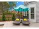 Backyard patio with lounge chairs, umbrella and mature trees at 520 Weatherend Ct, Johns Creek, GA 30022