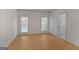 A bright bedroom with hardwood floors, two windows, and a neutral color scheme at 1155 Graystone Xing, Alpharetta, GA 30005