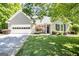 Charming brick home with a well-manicured lawn, an attached two-car garage, and a welcoming entrance at 1155 Graystone Xing, Alpharetta, GA 30005