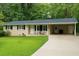 Charming single-story home with manicured lawn, black shutters, and covered parking in a lush setting at 3854 Bright Star Road, Douglasville, GA 30135