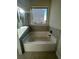 Corner tub with tile surround and black hardware with window view at 3867 Lockaby Way, Lawrenceville, GA 30044