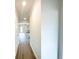 Light filled hallway with modern gray vinyl plank flooring and neutral paint throughout at 5443 Belle Meade Dr, Villa Rica, GA 30180