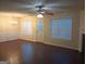 Open-concept living room features hardwood floors, natural lighting, and a ceiling fan at 6398 Shadow Sq, Lithonia, GA 30058