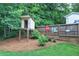 Backyard features an elevated playhouse, mature trees, landscaping and a partial privacy fence in a park-like setting at 80 Broadlands Dr, White, GA 30184
