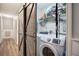 Laundry room with barn door, washer, dryer, and shelving for storage at 80 Broadlands Dr, White, GA 30184